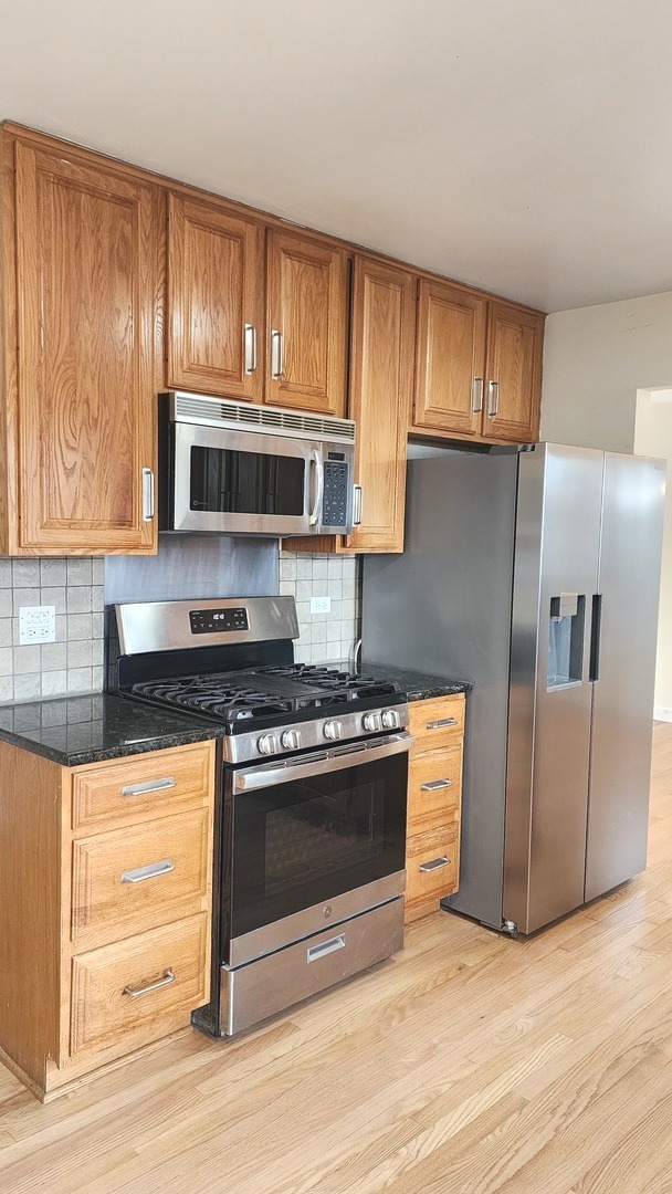 5 Castlegate Court Vernon Hills, IL 60061 - Photo 10 of 25 a kitchen with granite countertop wooden cabinets stainless steel appliances and a window