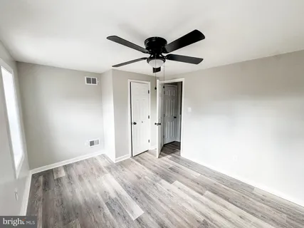 a view of a livingroom with a chandelier fan and wooden floor