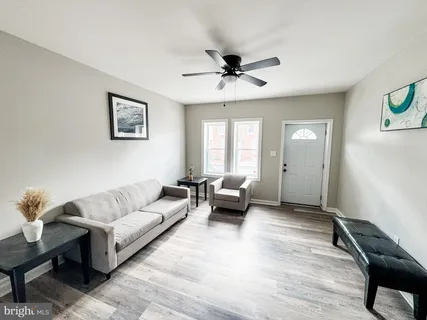a living room with furniture and a ceiling fan