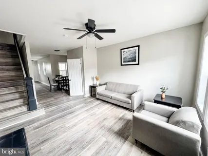 a living room with furniture and a wooden floor