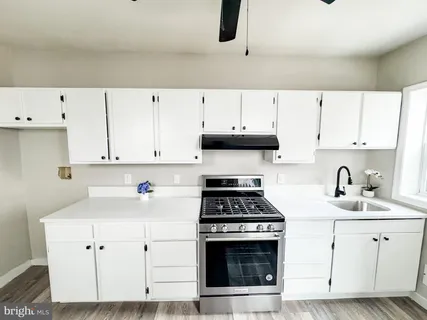 a kitchen with cabinets appliances a sink and a counter space