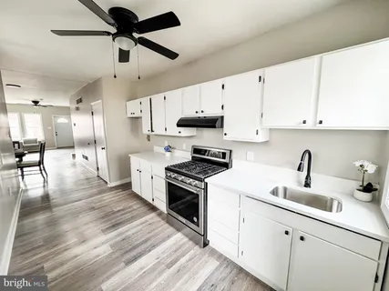 a kitchen with stainless steel appliances granite countertop a sink a stove and a refrigerator