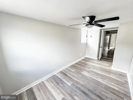 a view of hallway with wooden floor and ceiling fan