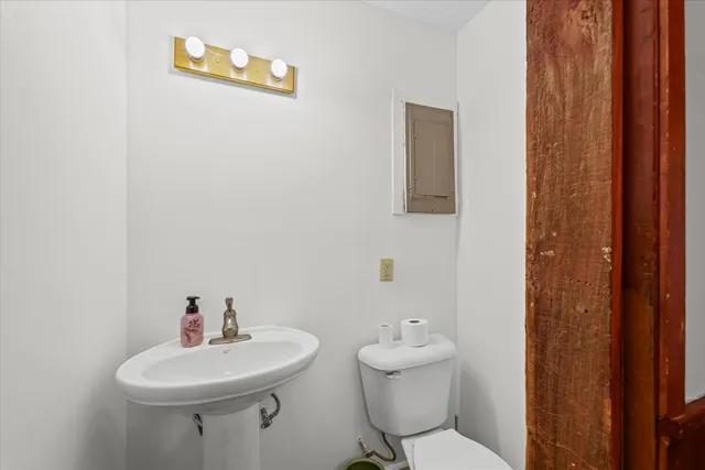 a bathroom with a sink a toilet and mirror