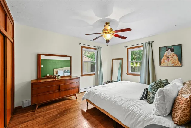 a bedroom with a bed and a mirror on the dresser