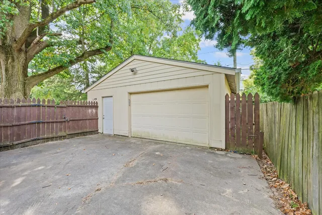 a view of backyard with small cabin and wooden fence