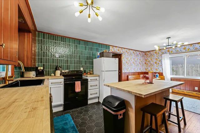 a kitchen with a refrigerator and a stove top oven