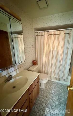 a bathroom with a sink toilet and window