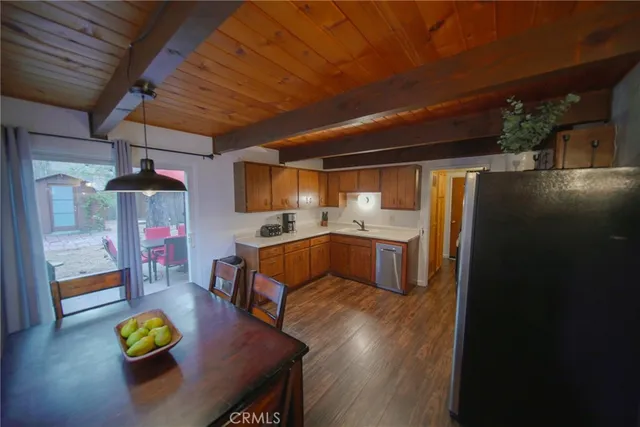 a living room with stainless steel appliances kitchen island granite countertop furniture and a wooden floor