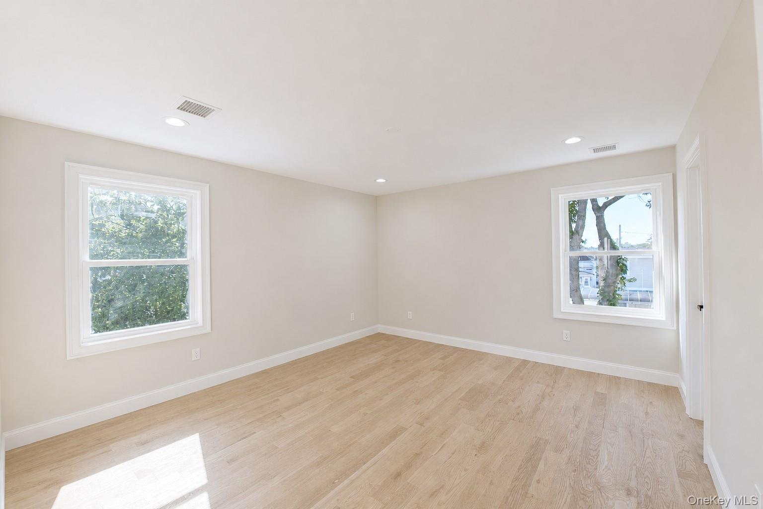 1316 R Street Elmont, NY 11003 - Photo 16 of 24 an empty room with wooden floor and windows
