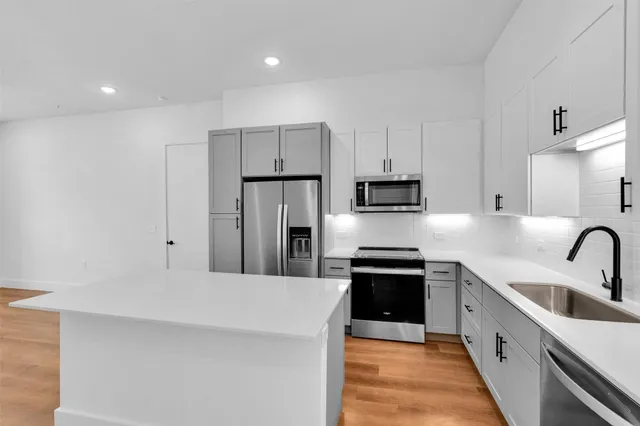 a kitchen with kitchen island a sink stainless steel appliances and cabinets