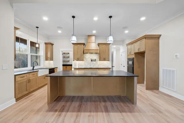 a large kitchen with cabinets wooden floor and stainless steel appliances