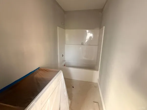 an empty room with windows and cabinet