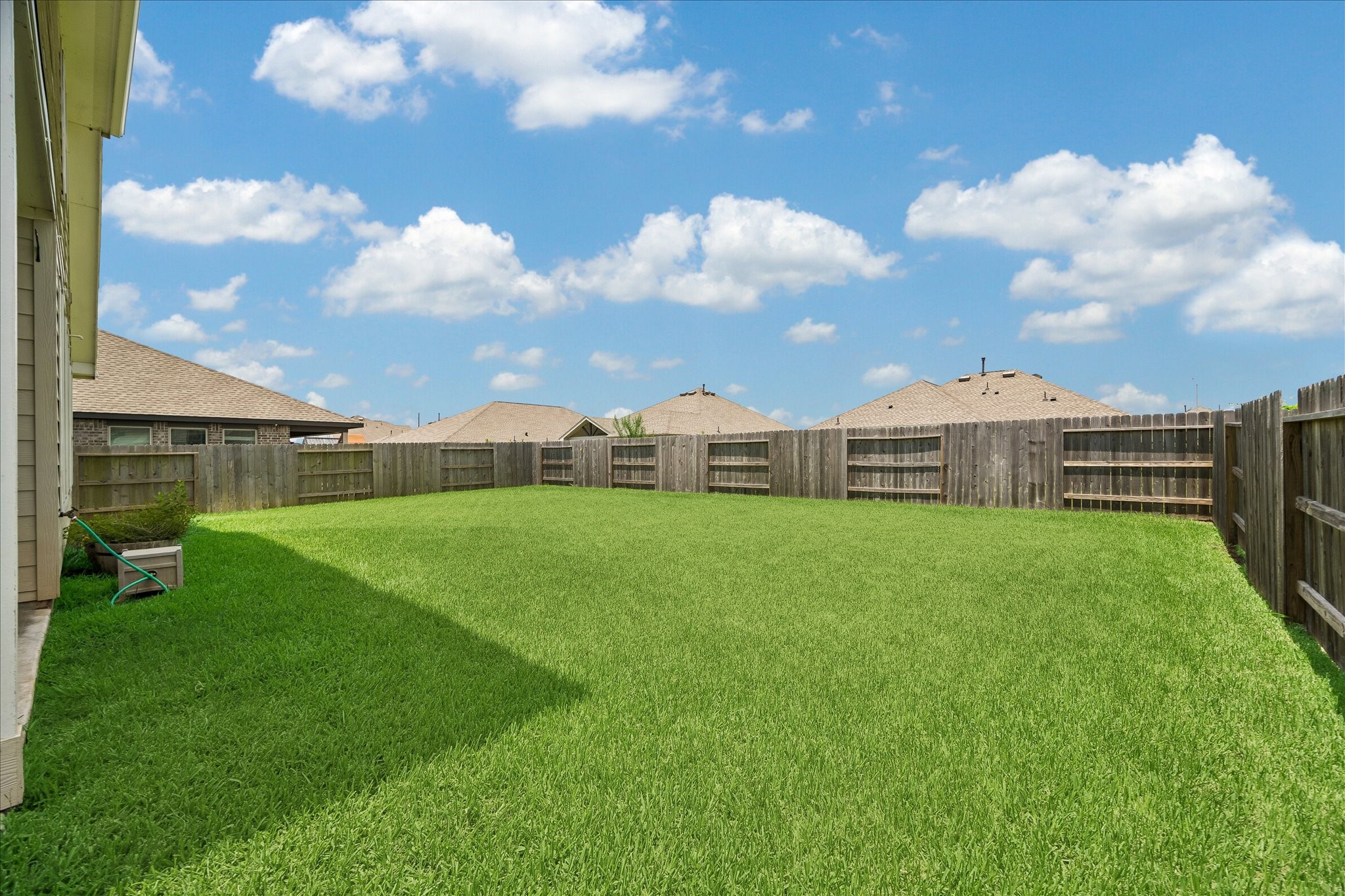 3812 Moss Hl Road Rosenberg, TX 77469 - Photo 20 of 20 Spacious backyard with lush green grass, enclosed by a wooden fence.
