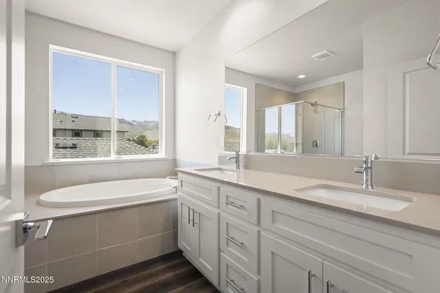 a bathroom with a granite countertop sink mirror and a bathtub