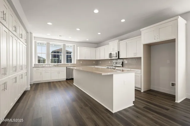 a kitchen with a wooden floor stove top oven and refrigerator