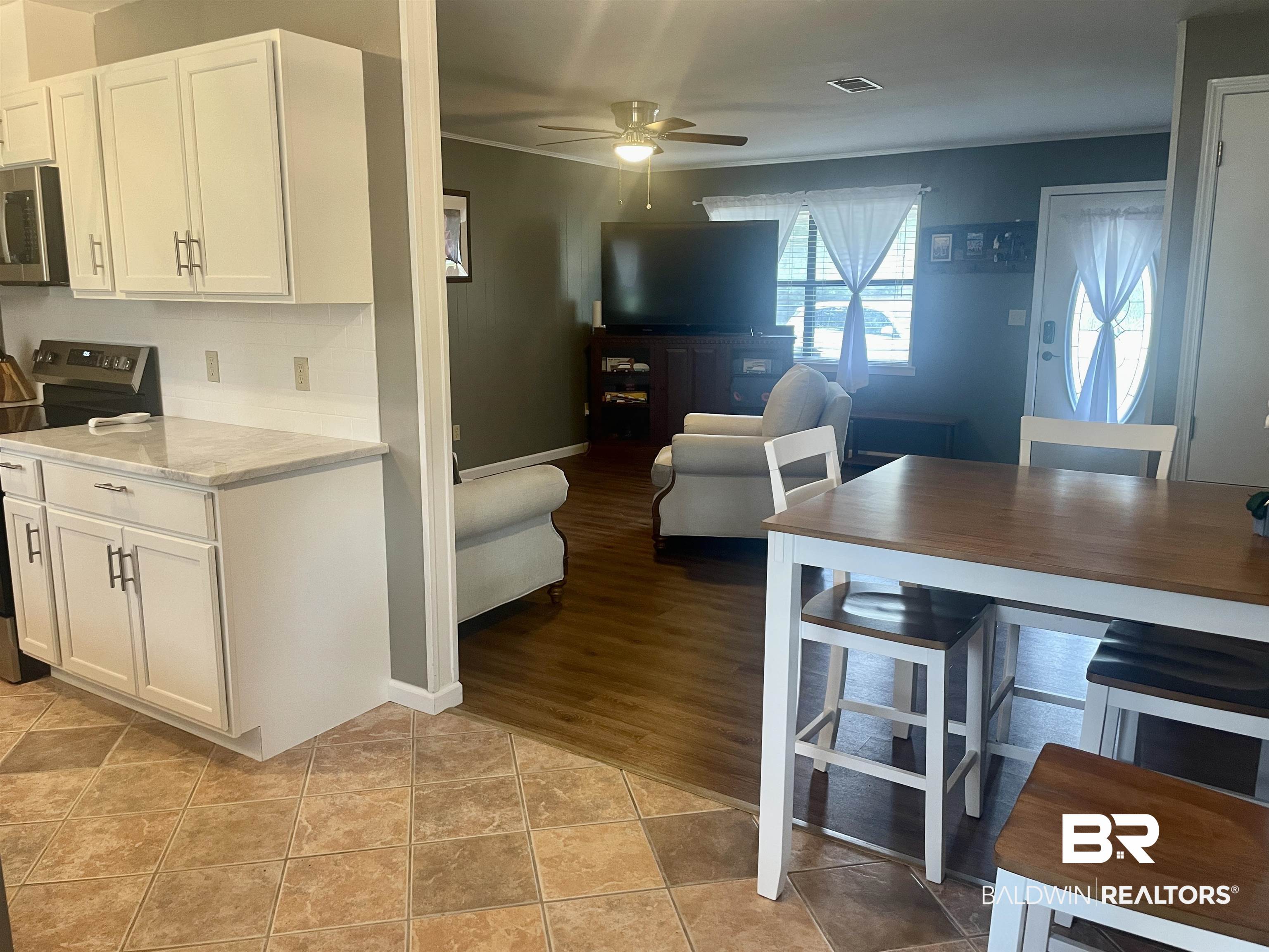 2274 Foshee Road Brewton, AL 36426 - Photo 23 of 23 Kitchen with stainless steel appliances, a ceiling fan, white cabinets, open floor plan, and backsplash