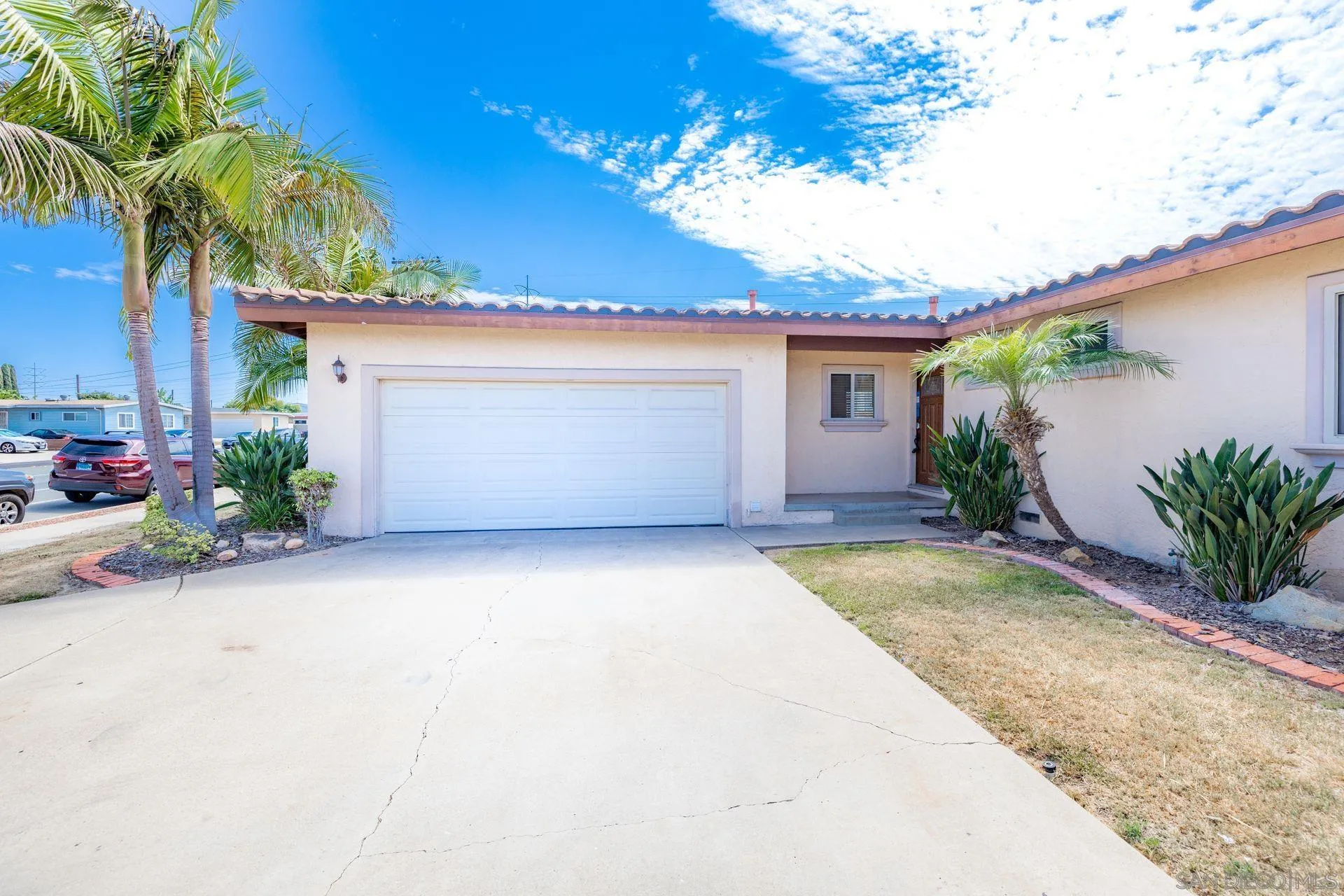 2742 Murray Ridge Road San Diego, CA 92123 - Photo 6 of 34 a view of a house with a yard and garage