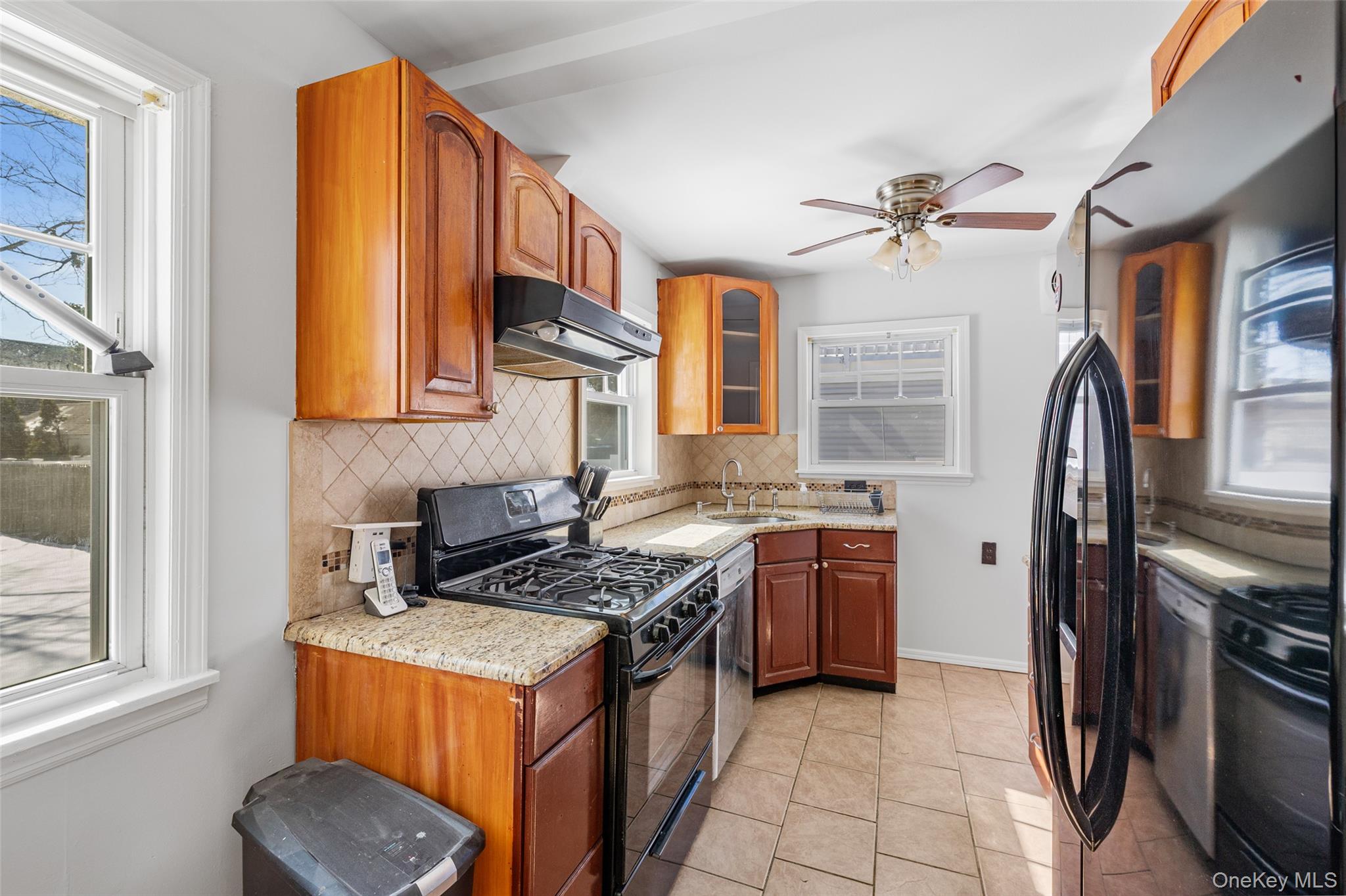 682 Rose Boulevard Baldwin, NY 11510 - Photo 2 of 22 a kitchen with stainless steel appliances granite countertop a stove a sink and a refrigerator
