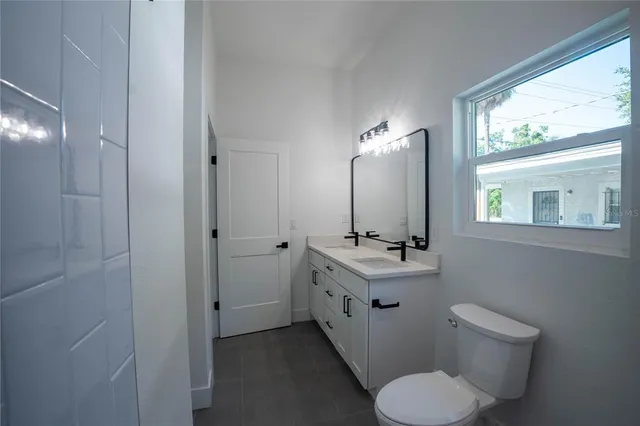 a bathroom with a toilet sink and mirror