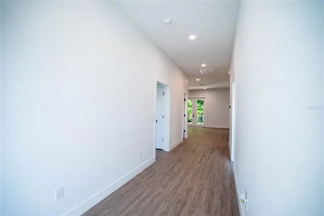a view of a hallway with wooden floor