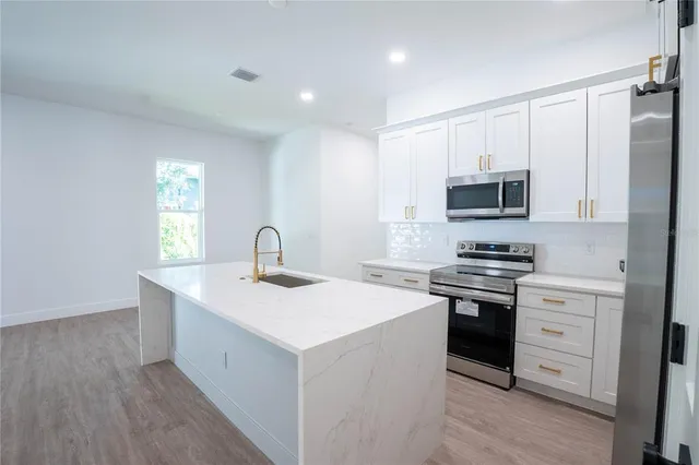 a kitchen with a sink appliances and cabinets