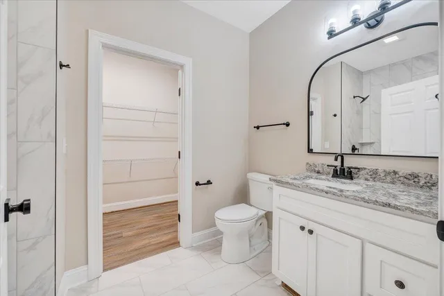 an empty room with wooden floor chandelier fan and windows