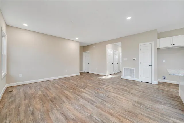 a kitchen with stainless steel appliances granite countertop a sink a stove a refrigerator and white cabinets