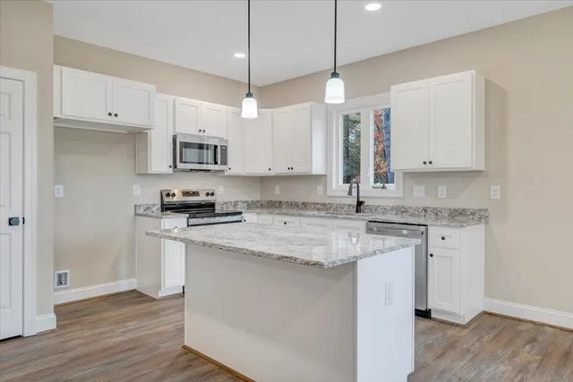 a kitchen with stainless steel appliances granite countertop a sink a stove and a refrigerator