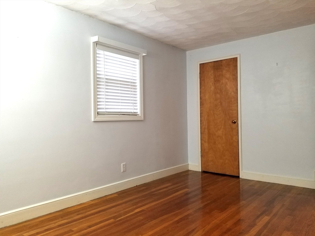 225 Governors Road, Unit 225 Quincy, MA 02169 - Photo 15 of 19 an empty room with wooden floor and windows