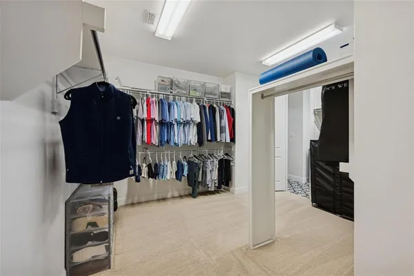a view of walk in closet with clothes and shoes