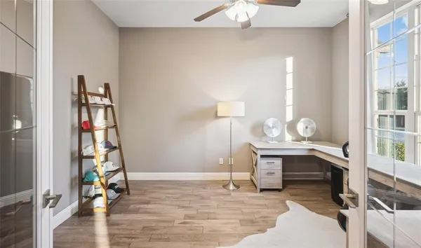 a view of a workspace with wooden floor and a window