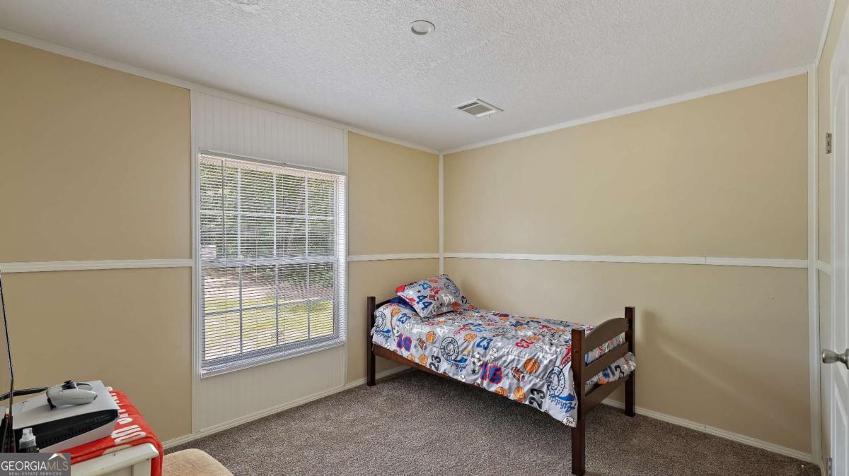 64 Sierra Road Jesup, GA 31545 - Photo 12 of 22 a bedroom with a bed and wooden floor