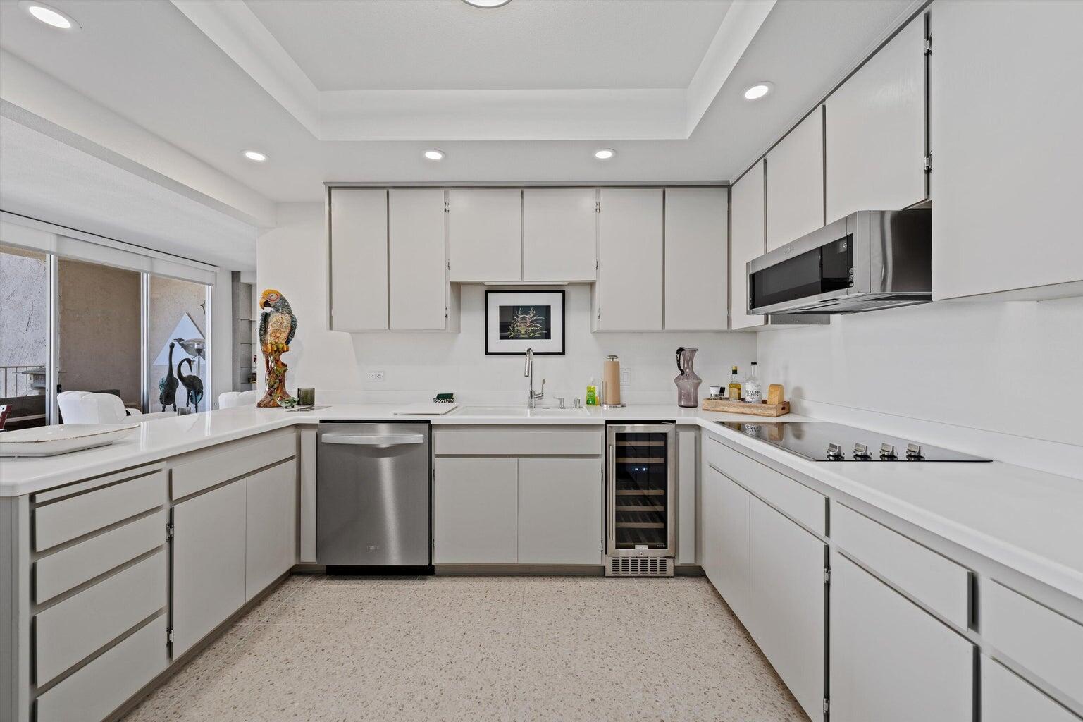 899 Island Drive, Unit 304 Rancho Mirage, CA 92270 - Photo 9 of 30 a kitchen with white cabinets stainless steel appliances and sink