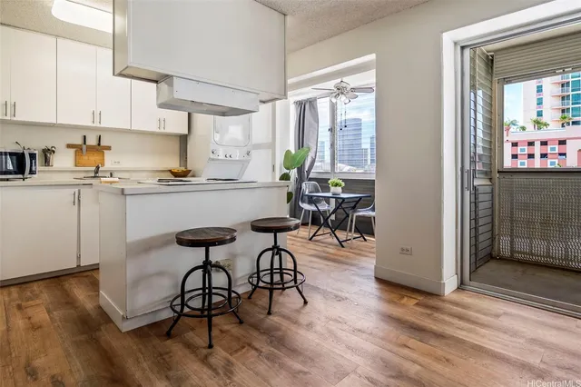 a kitchen with granite countertop a table chairs stove and cabinets