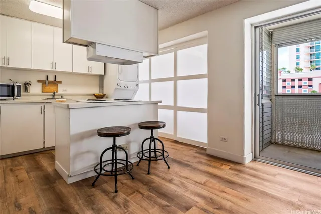a kitchen with granite countertop white cabinets and wooden floor