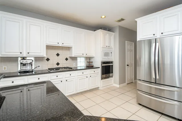a kitchen with granite countertop cabinets and stainless steel appliances