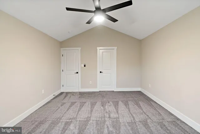 a view of an empty room with a ceiling fan