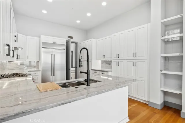 a view of a kitchen with kitchen island a sink stainless steel appliances and cabinets