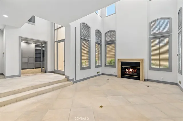 an empty room with windows and fireplace