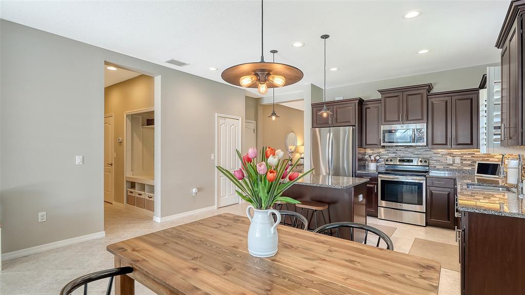 1318 Westover Avenue Parrish, FL 34219 - Photo 6 of 42 a kitchen with stainless steel appliances granite countertop a refrigerator a stove a sink white cabinets and a wooden floor
