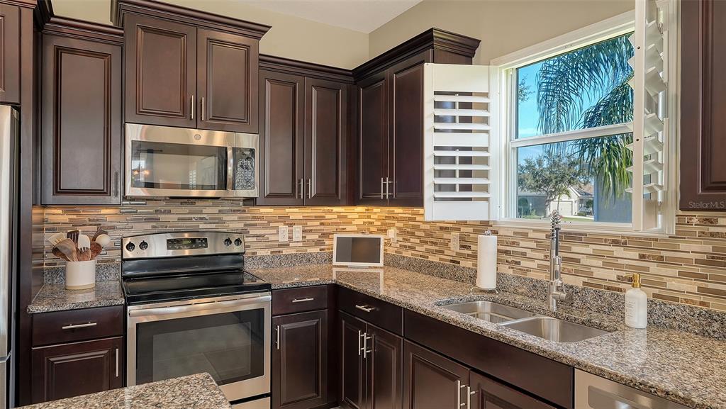 1318 Westover Avenue Parrish, FL 34219 - Photo 9 of 42 a kitchen with granite countertop a sink stove and cabinets
