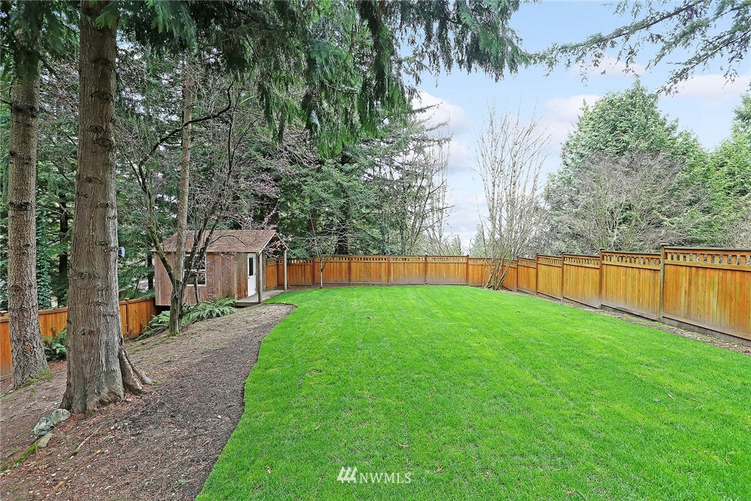 22415 1st Drive Southeast Bothell, WA 98021 - Photo 22 of 24 a view of a backyard with large trees and wooden fence