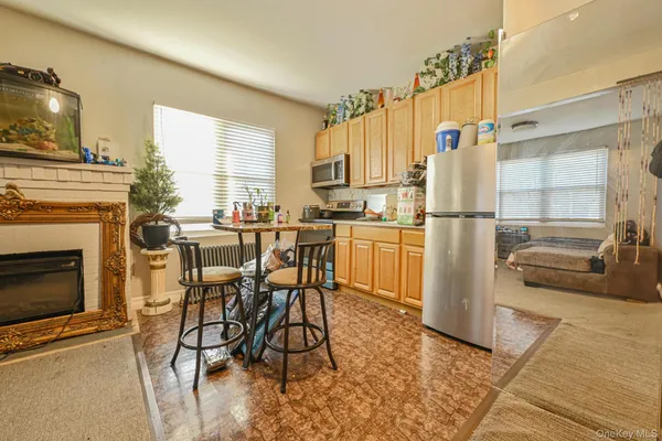 a kitchen with stainless steel appliances a refrigerator a stove a dining table and chairs