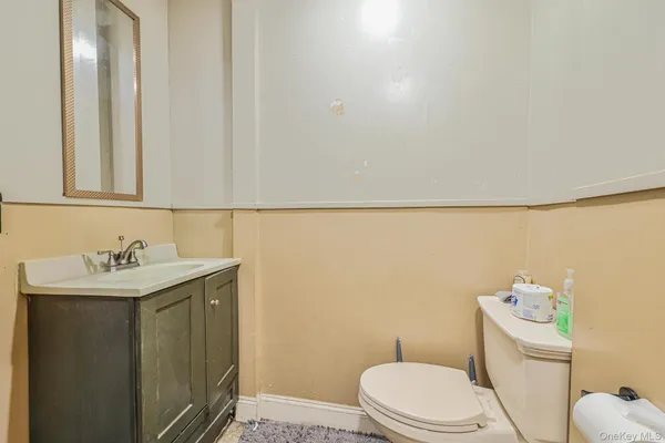 a bathroom with a toilet a sink and mirror