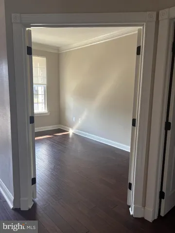 a view of a room with wooden floor and a window