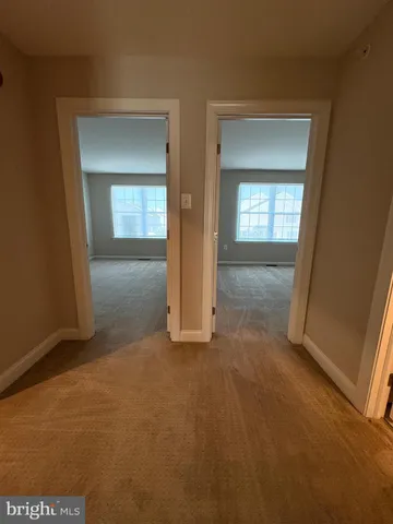 a view of an empty room with closet and a window