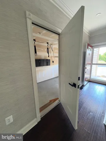 a view of a hallway with wooden floor and a living room