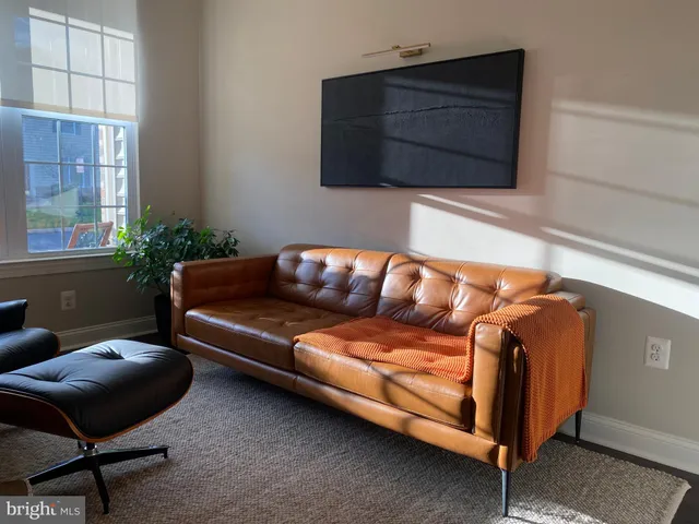 a blue couch sitting in a living room next to a window