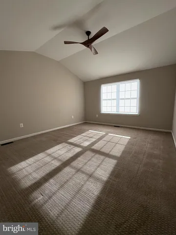 a view of a room with a ceiling fan and window